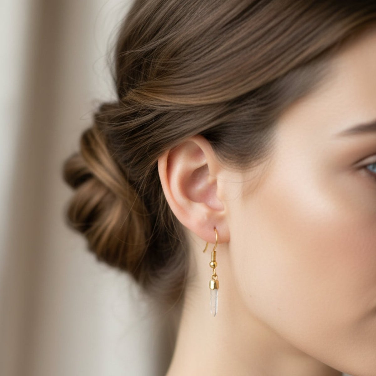 Gold Tibetan quartz crystal point earrings on a lady.