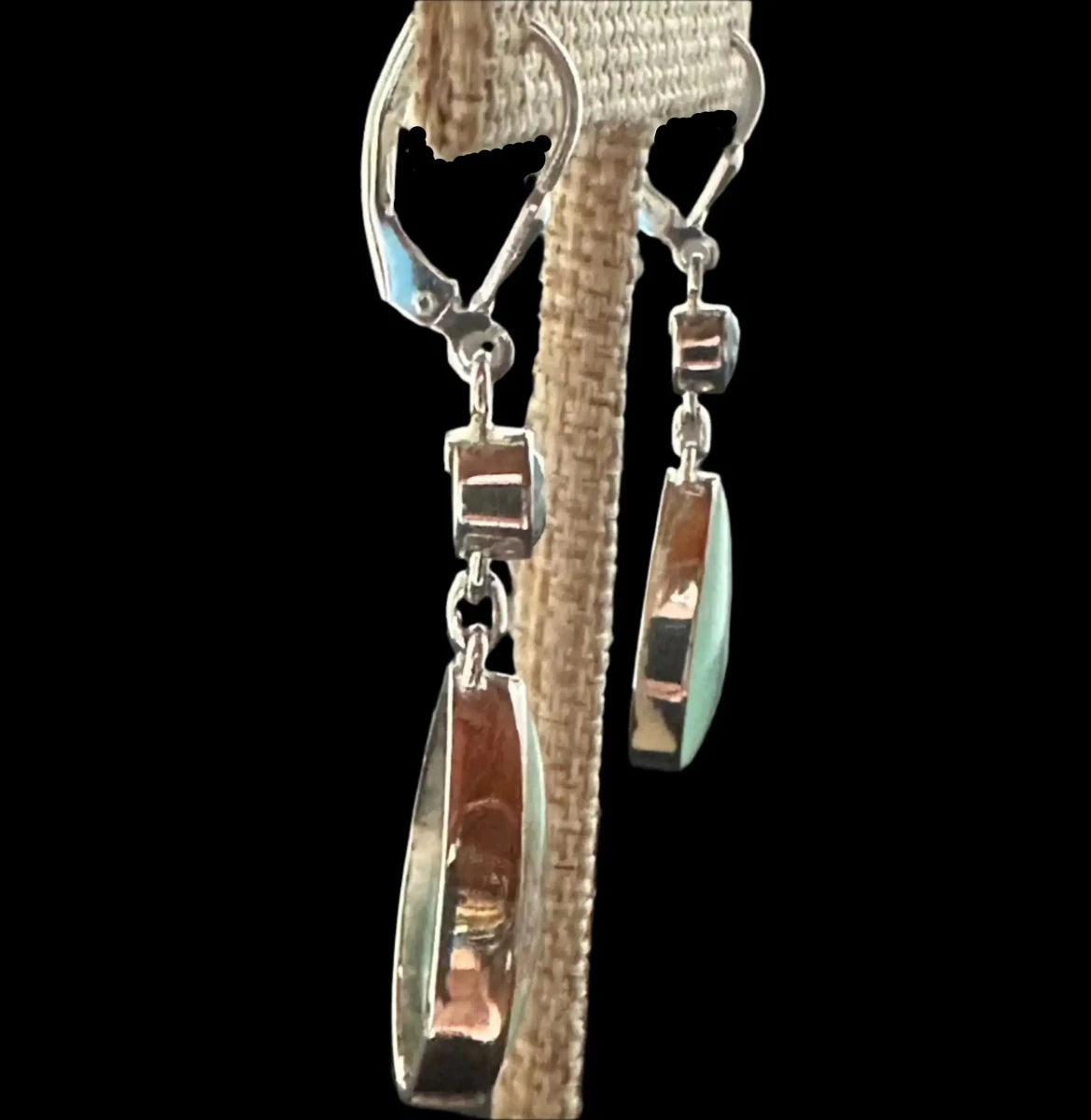 Side View Of Sterling Bezel Set Variscite Blue Topaz Earrings On A Display Stand