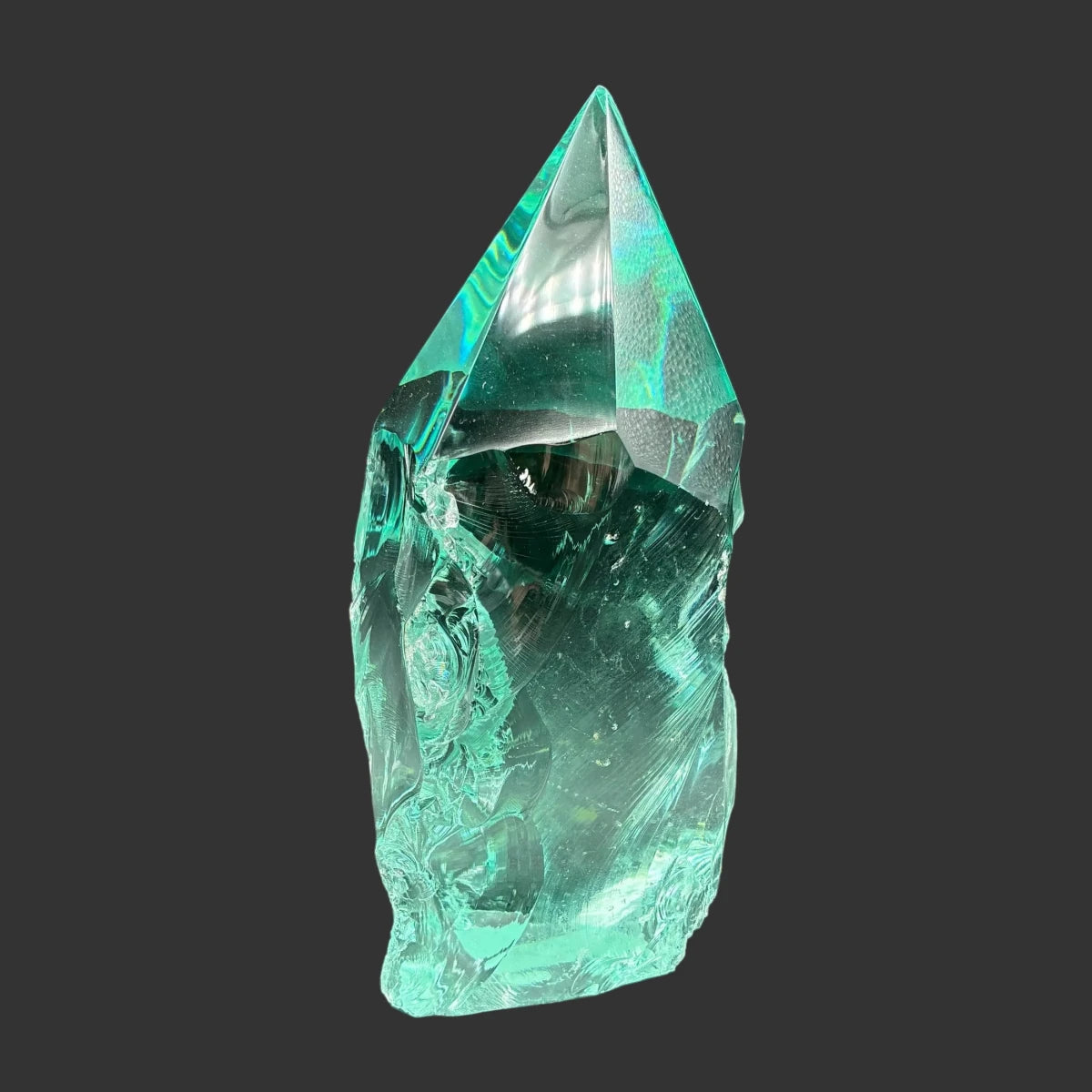 Front side of this blue green slag freeform, in front of a black background.