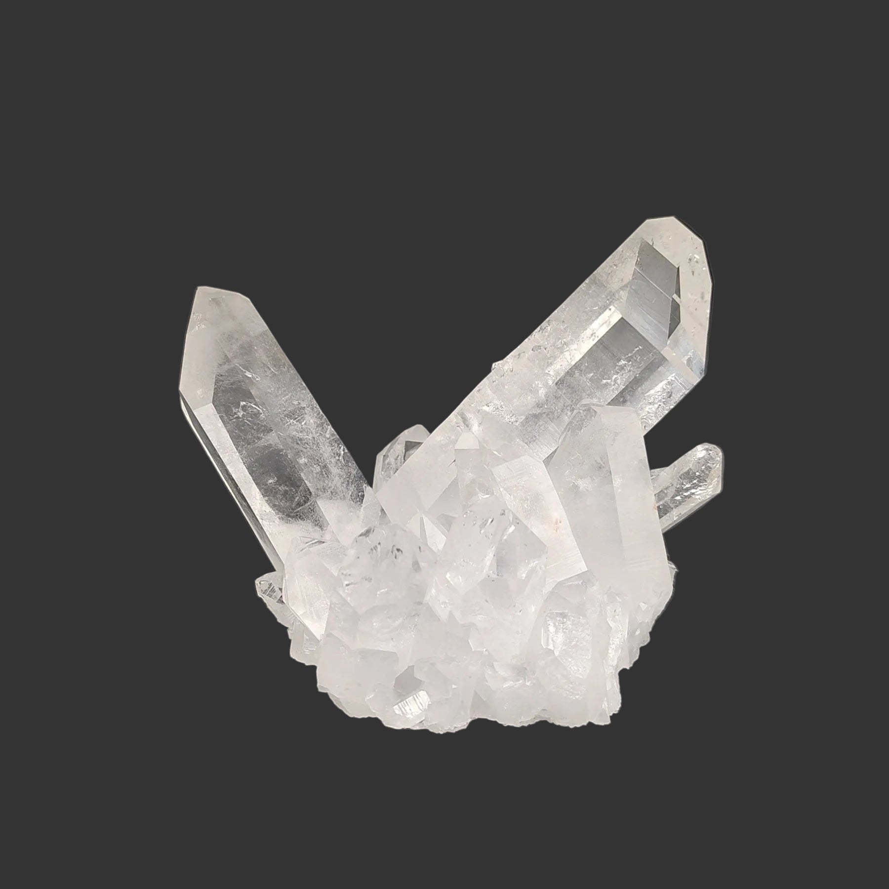 This is the front view of this Quartz crystal cluster, in front of a black background.