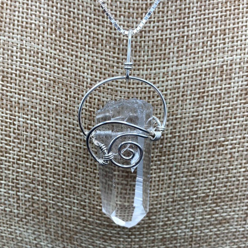 Close Up Of Crystal Pendant, Wrapped In Sterling Silver Wire In A Curly Design To Hold The Clear Crystal Point On The Necklace