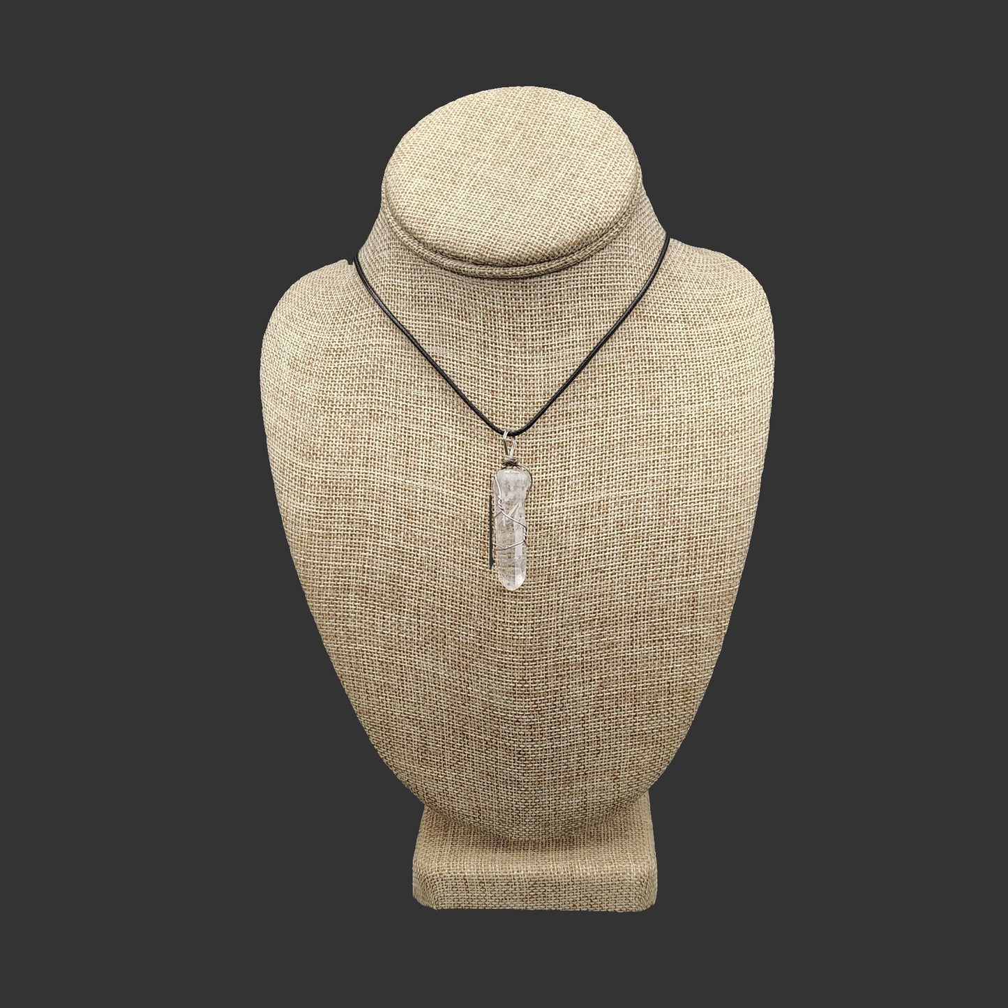 This beautiful wire wrapped quartz crystal point sits on a black leather cord necklace.