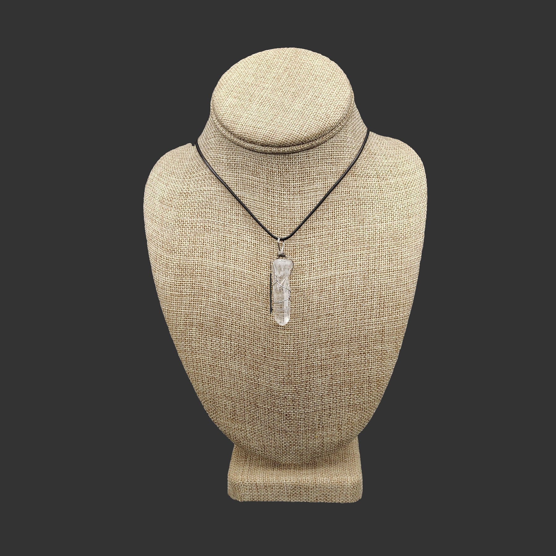 This beautiful wire wrapped quartz crystal point sits on a black leather cord necklace.