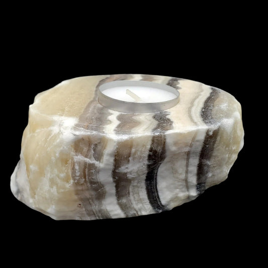 Cream, Brown, Gray, Black striped carved stone with a candle