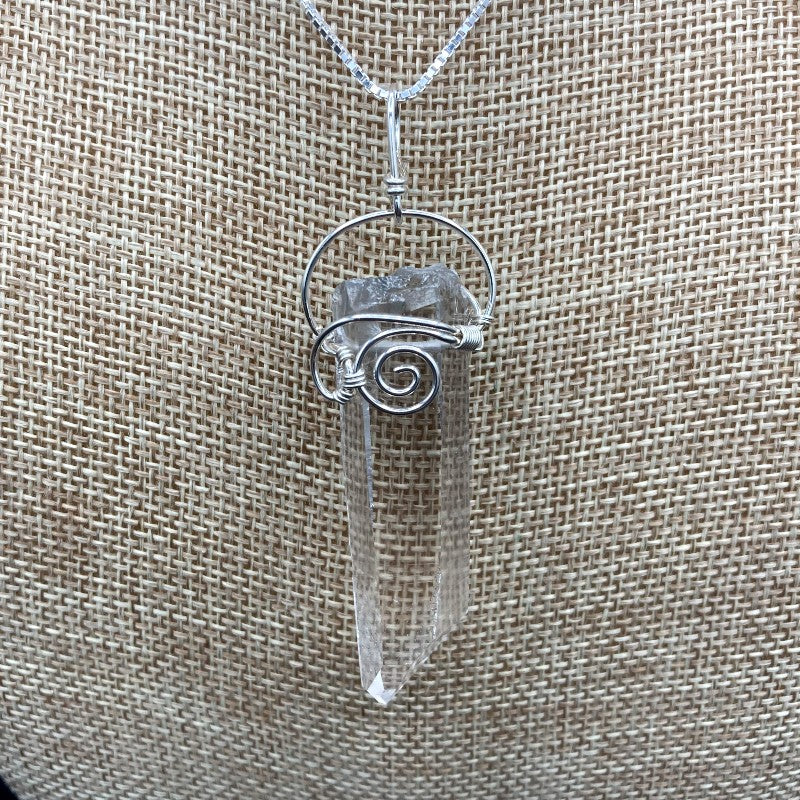 Close Up Of Water Clear Crystal Pendant, Sterling Silver Wire In A curly Design To Hold The Clear Crystal Point